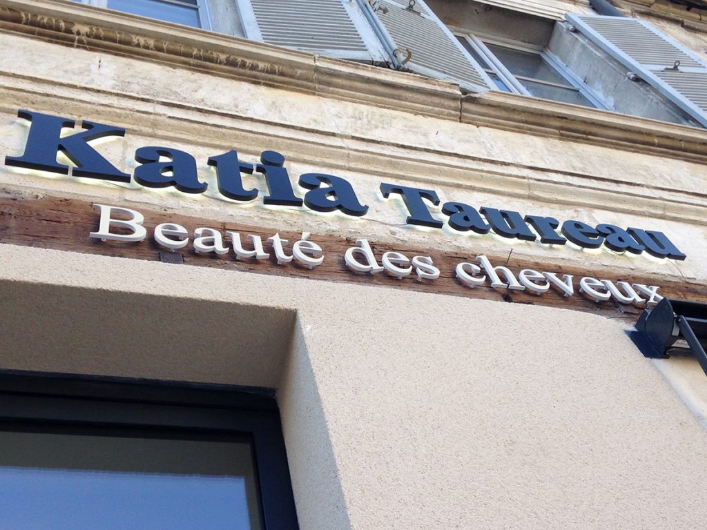 Installation d'une enseigne lumineuse avec lettrage sur entretoises pour un salon de coiffure